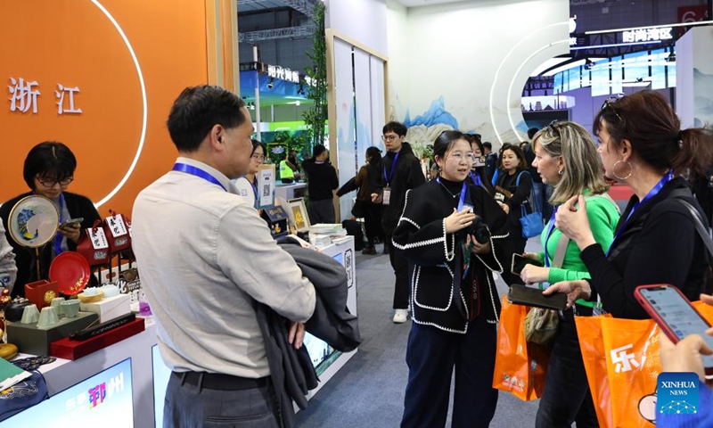 Visitors and exhibitors communicate at the booth of east China's Zhejiang Province during the China International Travel Mart 2024 in east China's Shanghai, Nov. 22, 2024. (Photo: Xinhua)