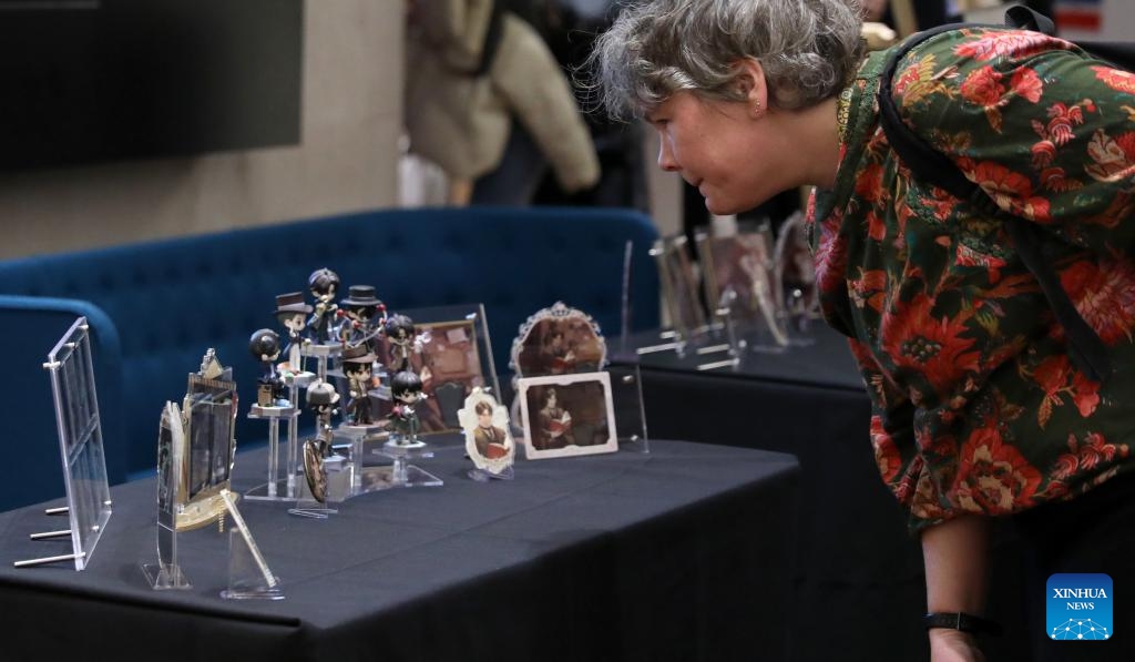 A visitor looks at themed products of Lord of the Mysteries during the inclusion event of ten online Chinese novels at the British Library in London, Britain, on Nov. 21, 2024. (Xinhua/Li Ying)