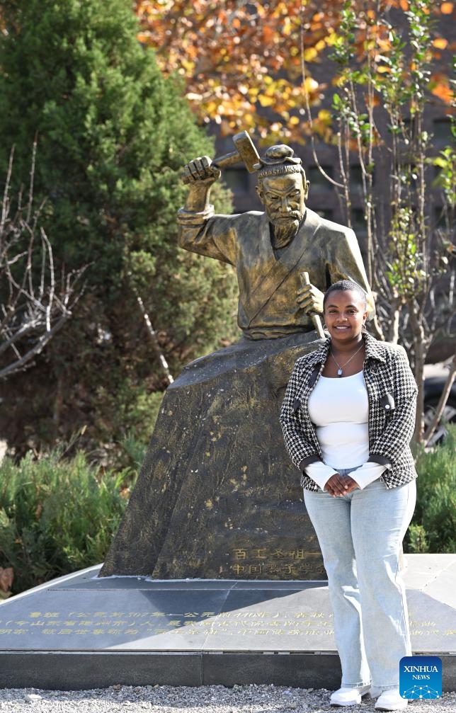 Kalkidan poses for a photo in front of the sculpture of Lu Ban, the revered Chinese artisan, at the Tianjin University of Technology and Education in Tianjin, north China, Nov. 22, 2024. (Photo: Xinhua)