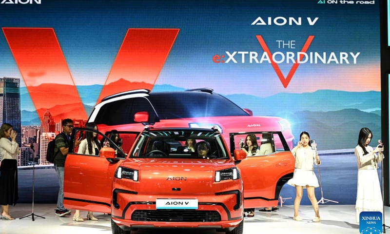 Cyberspace influencers are pictured around a vehicle displayed at the booth of Chinese auto brand Aion during opening of Gaikindo Jakarta Auto Week (GJAW) 2024 in Tangerang, Banten Province, Indonesia, Nov. 22, 2024. The auto show is held here from Nov. 22 to Dec. 1. (Xinhua/Agung Kuncahya B.)