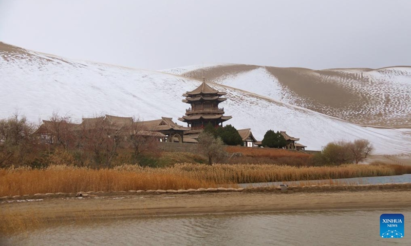 This photo taken on Nov. 23, 2024 shows snow scenery of the Mingsha Mountain and Crescent Spring scenic spot in Dunhuang, northwest China's Gansu Province. (Photo by Zhang Xiaoliang/Xinhua)