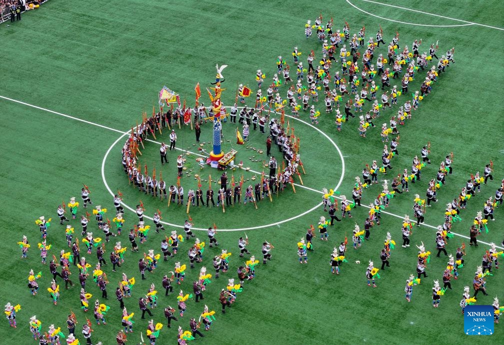 An aerial drone photo shows people in traditional costumes participating in Lusheng and horse fighting festival held in Rongshui Miao Autonomous County of Liuzhou, south China's Guangxi Zhuang Autonomous Region, Nov. 23, 2024. Lusheng is a folk musical instrument made of bamboo pipes. (Photo by Zheng Changhao/Xinhua)