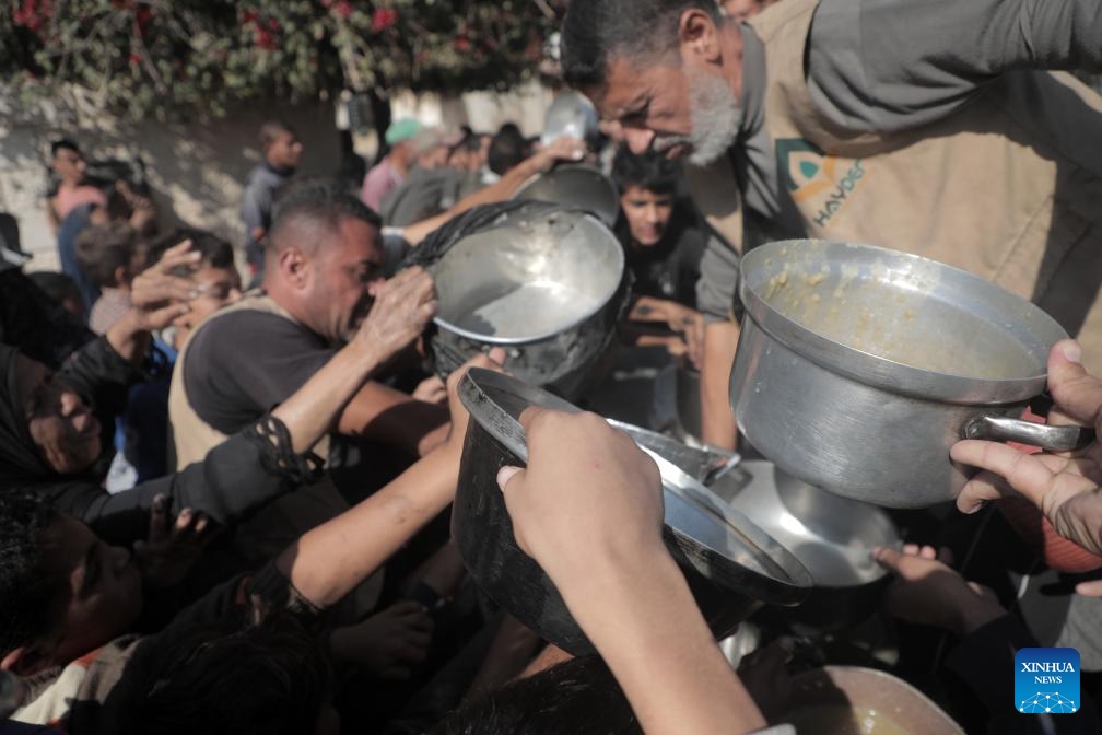 Palestinians receive free food at a food distribution center in the city of Deir al-Balah, central Gaza Strip, on Nov. 23, 2024. (Photo by Rizek Abdeljawad/Xinhua)