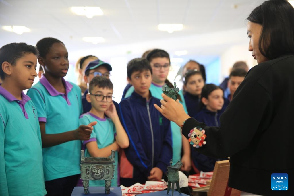 Students view Chinese cultural artifacts during the Confucius-themed photo exhibition in Qormi, Malta, on Nov. 22, 2024. (Xinhua/Chen Wenxian)