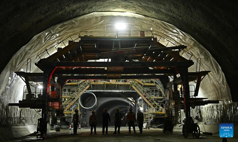 Staff members walk past a construction site of the new Jiaozhou Bay tunnel in Qingdao, east China's Shandong Province, Nov. 24, 2024. (Xinhua/Li Ziheng)