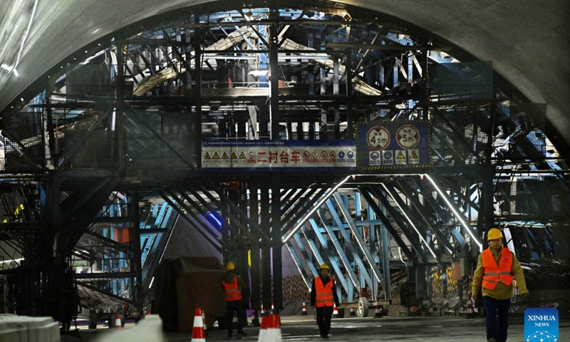 Staff members walk past a construction site of the new Jiaozhou Bay tunnel in Qingdao, east China's Shandong Province, Nov. 24, 2024. (Xinhua/Li Ziheng)