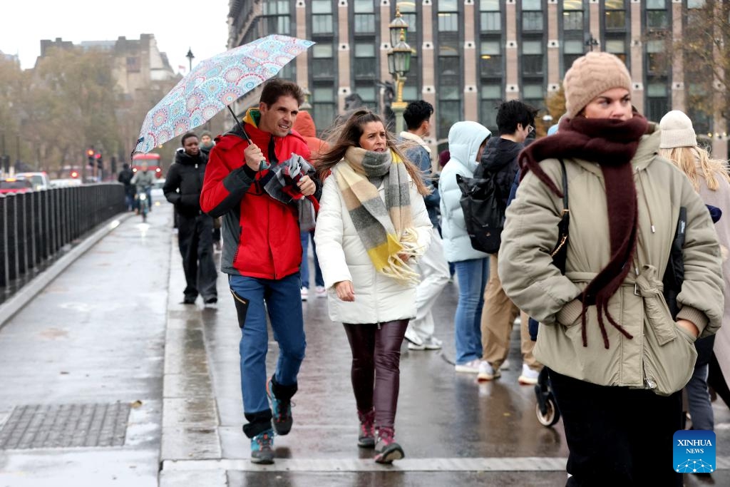 People walk on the Westminster Bridge in London, Britain, Nov. 23, 2024. Strong winds, heavy rain, and flooding brought by Storm Bert caused travel disruption and power outages across Britain over the weekend, leaving three men dead. (Xinhua)