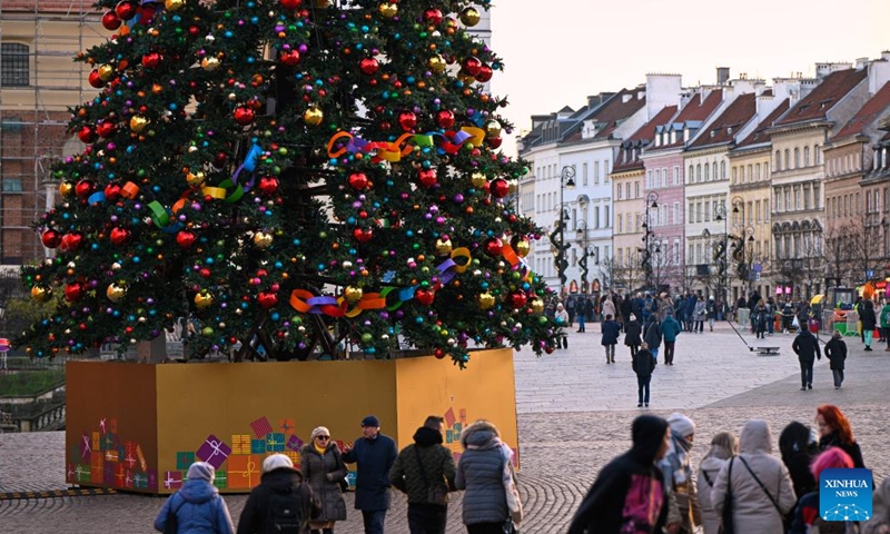 People walk past a Christmas tree in Warsaw, Poland, on Nov. 25, 2024. (Photo: Xinhua)