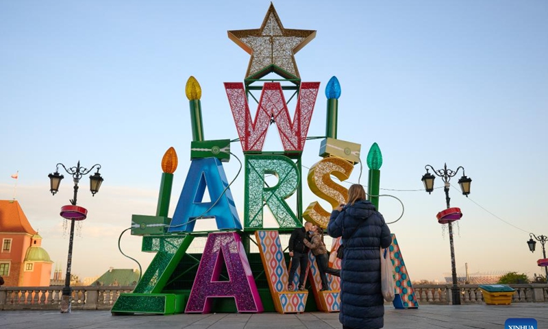 Visitors are seen in front of a light decoration in Warsaw, Poland, on Nov. 25, 2024. (Photo: Xinhua)