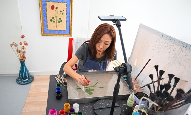 Li Xintong works on a piece of Ebru creation in Istanbul, Türkiye, Nov. 5, 2024. Ebru, or the Turkish art of paper marbling, is a traditional painting art. To create an Ebru, the artist will have to paint on water and then transfer this painting onto paper. In 2014, Ebru was officially listed as a UNESCO World Intangible Culture Heritage. (Photo: Xinhua)