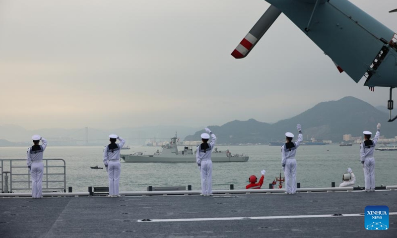 Crew members of the Hainan amphibious assault ship wave on board in Hong Kong, south China, Nov. 25, 2024. A Chinese People's Liberation Army Navy fleet comprising the Hainan amphibious assault ship and the Changsha missile destroyer visited Hong Kong from Nov. 21 to 25. (Photo: Xinhua)