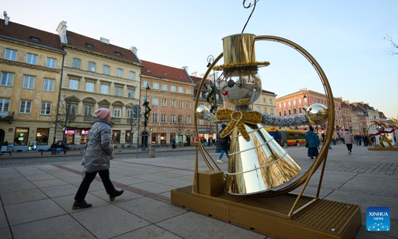 A woman walks past a festive decoration in the Old Town of Warsaw, Poland, on Nov. 25, 2024. (Photo: Xinhua)