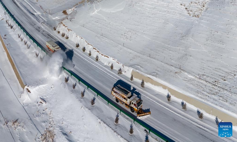 An aerial drone photo taken on Nov. 25, 2024 shows snowplows at work on a highway in Sunan Yugur Autonomous County, northwest China's Gansu Province. (Photo: Xinhua)