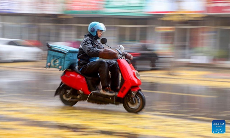 A delivery courier rides in the rain in Gaomi, east China's Shandong Province, Nov. 25, 2024. (Photo: Xinhua)