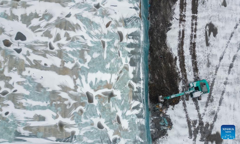 An aerial drone photo shows staff members removing the thermal insulation material covering an ice cube reserve ahead of the construction of the 26th Harbin Ice-Snow World in Harbin, northeast China's Heilongjiang Province, Nov. 26, 2024. (Photo: Xinhua)