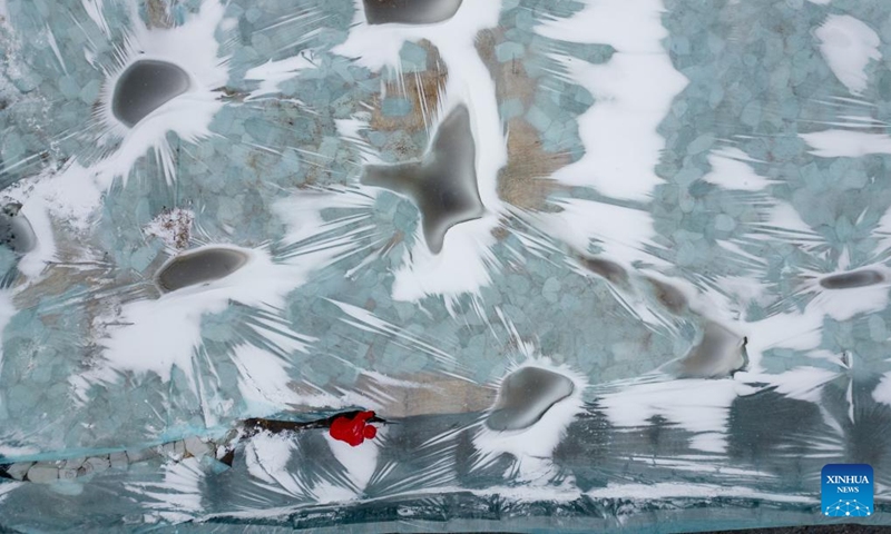 An aerial drone photo shows a staff member removing the thermal insulation material covering an ice cube reserve ahead of the construction of the 26th Harbin Ice-Snow World in Harbin, northeast China's Heilongjiang Province, Nov. 26, 2024. (Photo: Xinhua)