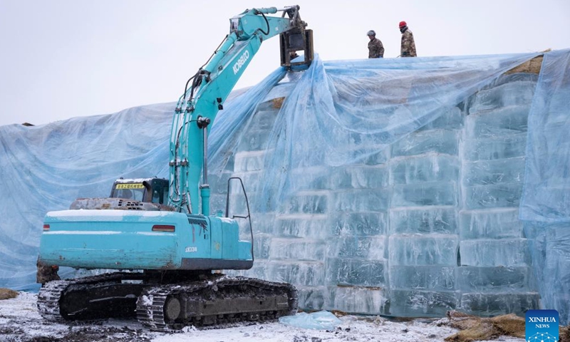 Staff members remove the thermal insulation material covering an ice cube reserve ahead of the construction of the 26th Harbin Ice-Snow World in Harbin, northeast China's Heilongjiang Province, Nov. 26, 2024. (Photo: Xinhua)