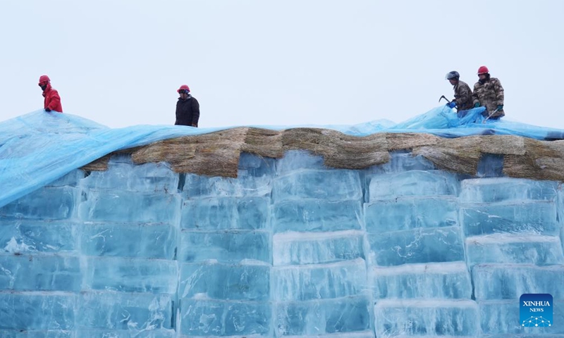 Staff members remove the thermal insulation material covering an ice cube reserve ahead of the construction of the 26th Harbin Ice-Snow World in Harbin, northeast China's Heilongjiang Province, Nov. 26, 2024. (Photo: Xinhua)