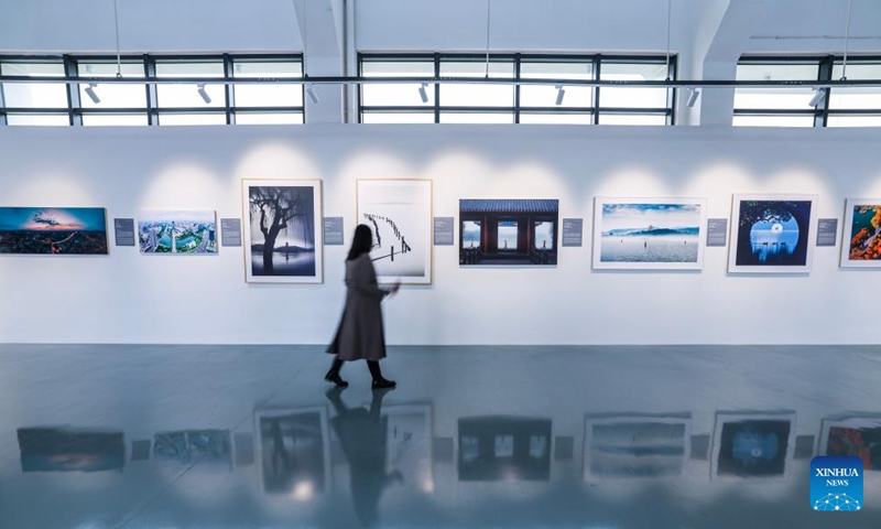 A woman visits a photography exhibition themed on China's world heritage in Hangzhou, east China's Zhejiang Province, Nov. 25, 2024. The exhibition held here on Monday presents China's 59 sites that have been inscribed on the UNESCO World Heritage List. (Photo: Xinhua)