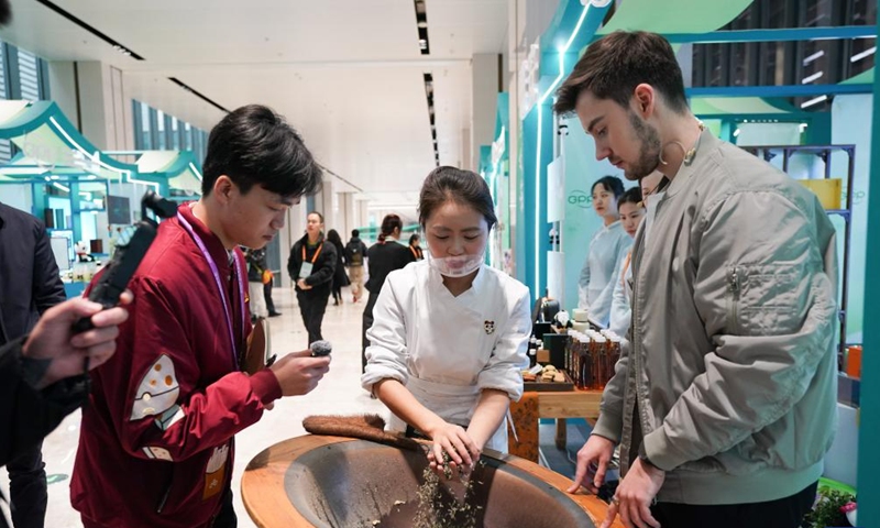 A foreign guest learns about the Ya'an tea-making technique during the Global Panda Partners 2024 conference in Chengdu, southwest China's Sichuan Province, Nov. 26, 2024. The event opened here on Tuesday with the theme Harmonious Coexistence Between Man and Nature. (Photo: Xinhua)