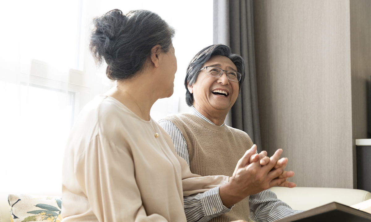 A senior couple browse through a photo album. Photo: VCG