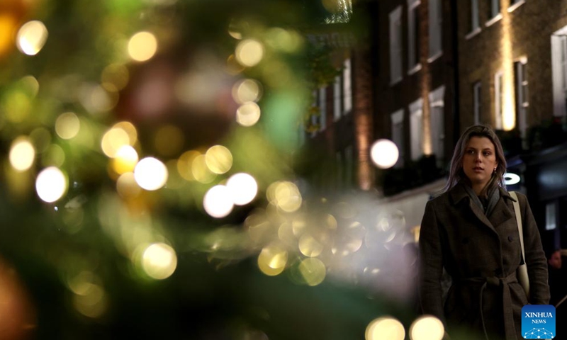 A woman walks on Regent Street decorated with lights in central London, Britain, on Nov. 27, 2024. (Xinhua/Li Ying)