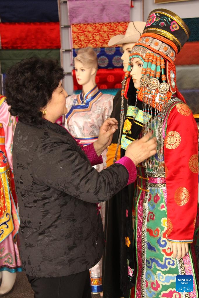 This photo taken on March 15, 2023 shows Meng Genhua arranging newly-made Mongolian ethnic attire in Otog Front Banner in the city of Ordos, north China's Inner Mongolia Autonomous Region. (Xinhua)