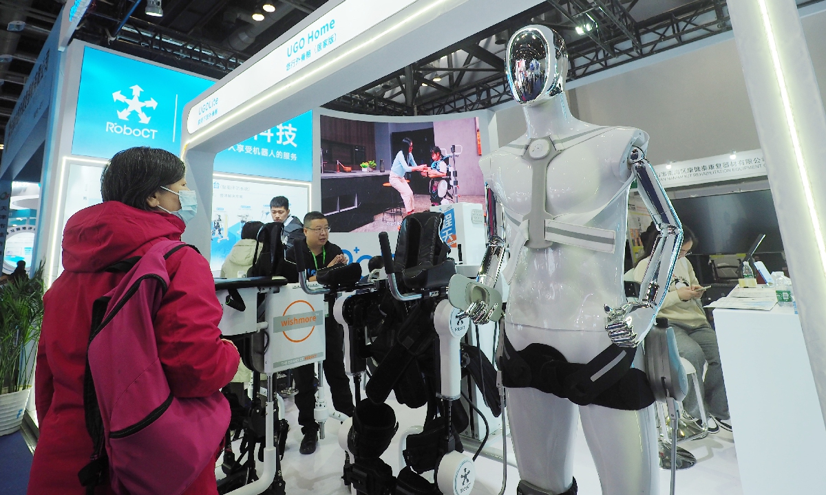 A spectator looks at an exoskeleton robot at the Care & Rehabilitation Expo China 2024 in Beijing National Convention Center on November 28, 2024. According to a report released at the First Chinese Humanoid Robot Industry Conference, China's market scale of the humanoid robot industry is predicted to reach 2.76 billion yuan ($381 million) in 2024. Photo: VCG