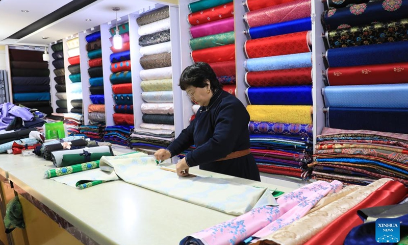 Meng Genhua cuts cloth for Mongolian ethnic attire making in Otog Front Banner in the city of Ordos, north China's Inner Mongolia Autonomous Region, Nov. 27, 2024. (Xinhua)