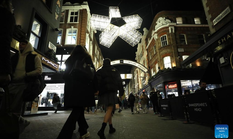 People walk on Carnaby Street decorated with lights in central London, Britain, on Nov. 27, 2024. (Xinhua/Li Ying)