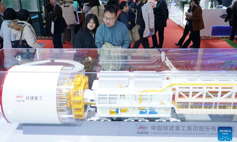 Visitors view a model of China's home-grown super-large-diameter shield tunneling machine Jinghua at the booth of China Railway Construction Corporation (CRCC) in the Advanced Manufacturing Chain exhibition area of the second China International Supply Chain Expo in Beijing, capital of China, Nov. 27, 2024.  (Xinhua/Zhang Chenlin)