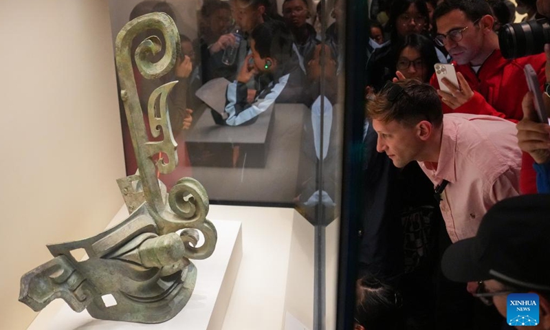 Evan Kail views a bronze mask discovered at the Sanxingdui Ruins site while visiting the Ancient China exhibition at National Museum of China in Beijing, capital of China, Nov. 19, 2024. (Xinhua/Ju Huanzong)