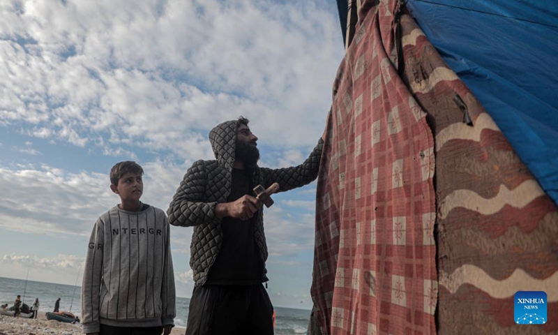 Odai Olaiwa (R) fixes a tent on the seaside in the city of Deir al-Balah in central Gaza Strip, Nov. 28, 2024. (Photo: Xinhua)