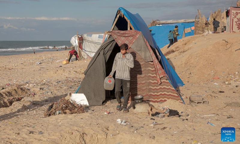 A child of Odai Olaiwa is about to fetch water on the seaside in the city of Deir al-Balah in central Gaza Strip, Nov. 28, 2024.(Photo: Xinhua)