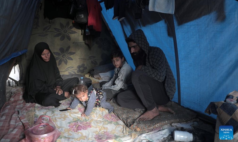 Odai Olaiwa (1st R) and his family are pictured inside a tent on the seaside in the city of Deir al-Balah in central Gaza Strip, Nov. 28, 2024. (Photo: Xinhua)