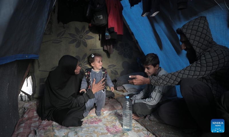 Odai Olaiwa (1st R) and his family are pictured inside a tent on the seaside in the city of Deir al-Balah in central Gaza Strip, Nov. 28, 2024. (Photo: Xinhua)