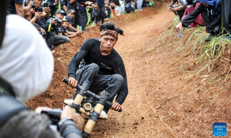 A participant rides a traditional wooden cart, known locally as kadaplak, downhill at Cisurupan in Bandung, West Java Province, Indonesia, Nov. 28, 2024. (Photo by Septianjar Muharam/Xinhua)