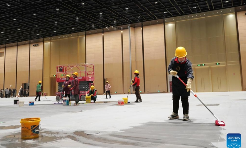 Staff members perform cleaning work inside a convention and exhibition center as part of the second phase project of the China National Convention Center, in Beijing, capital of China, Nov. 28, 2024.