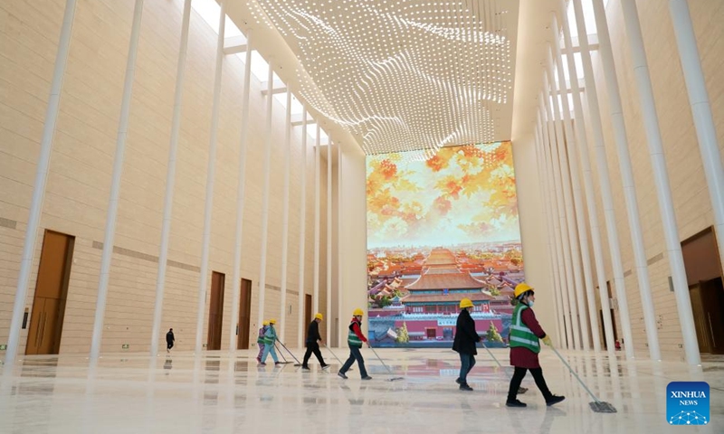 Staff members perform cleaning work inside a convention and exhibition center as part of the second phase project of the China National Convention Center, in Beijing, capital of China, Nov. 28, 2024. 