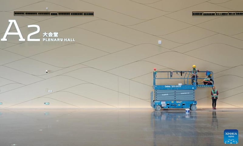 Staff members perform cleaning work inside a convention and exhibition center as part of the second phase project of the China National Convention Center, in Beijing, capital of China, Nov. 28, 2024. 