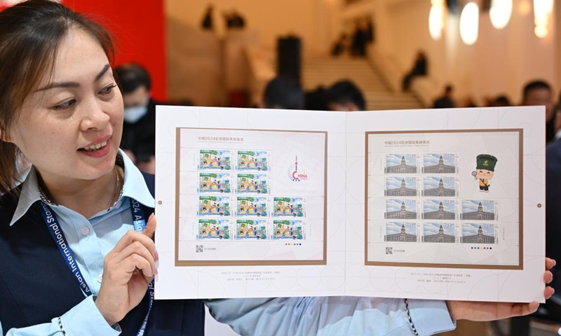 A staff member shows commemorative stamps issued by China Post for China 2024 Asian International Stamp Exhibition at Shanghai Exhibition Center in east China's Shanghai on Nov. 29, 2024. The exhibition opened on Friday and will last for 5 days. (Photo: Xinhua)