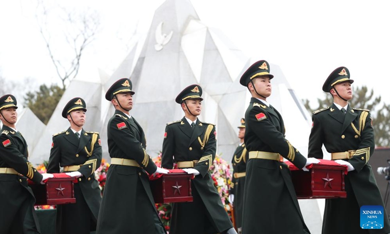 Guards of honor escort the caskets of the fallen Chinese People's Volunteers (CPV) martyrs during a burial ceremony at the CPV martyrs' cemetery in Shenyang, northeast China's Liaoning Province, Nov. 29, 2024. (Photo by Han Qiyang/Xinhua)