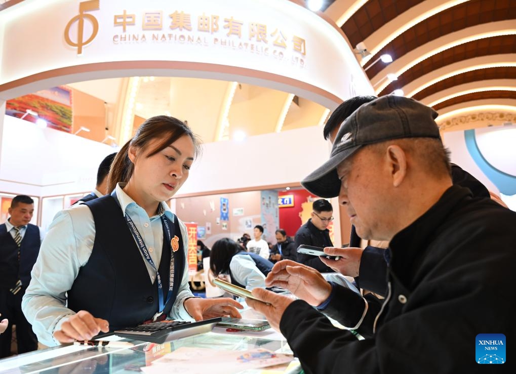 Visitors select stamps at China 2024 Asian International Stamp Exhibition at Shanghai Exhibition Center in east China's Shanghai on Nov. 29, 2024. The exhibition opened on Friday and will last for 5 days. (Xinhua/Li He)