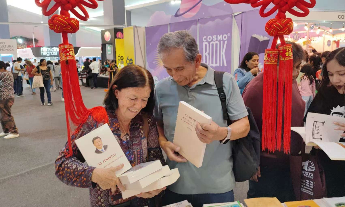 A Peruvian couple purchase <em>Xi Jinping: The Governance of China</em> at the Lima International Book Fair 2024.
Photo: Courtesy of Meng Kexin