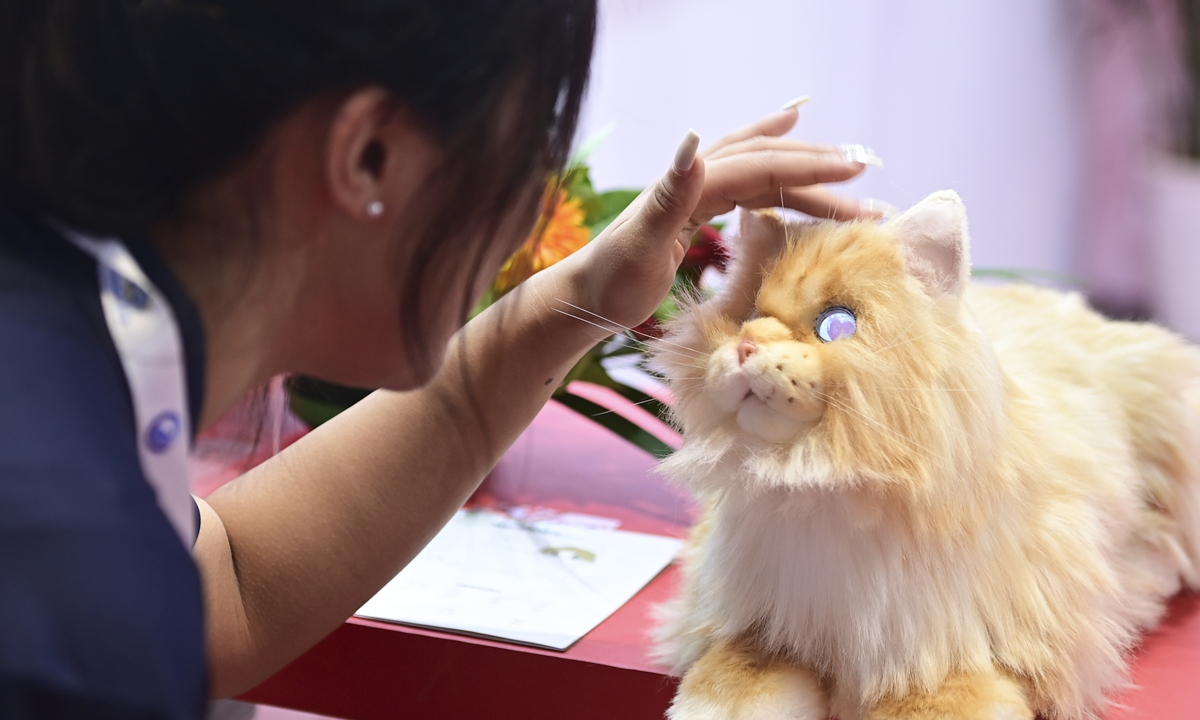 A visitor rinteracts with a simulated pet cat. Photo: VCG