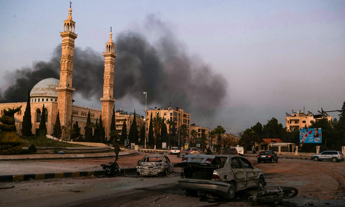 Destroyed cars can be seen as smoke billows at a site in Aleppo, in northern Syria on November 30, 2024. Anti-government troops breached Syria's second city of Aleppo on November 29. Photo: VCG