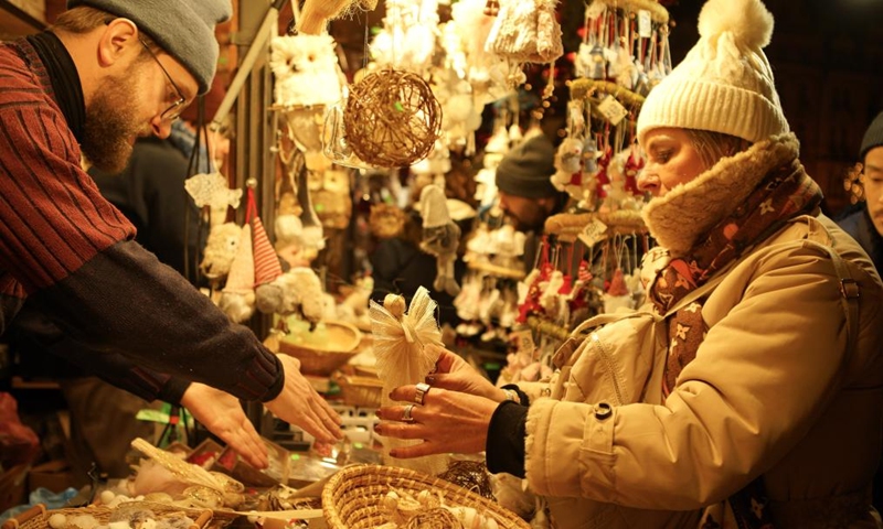 A woman chooses holiday decorations at a Christmas market at the Old Town Square in Prague, the Czech Republic, on Nov. 30, 2024. Photo: Xinhua