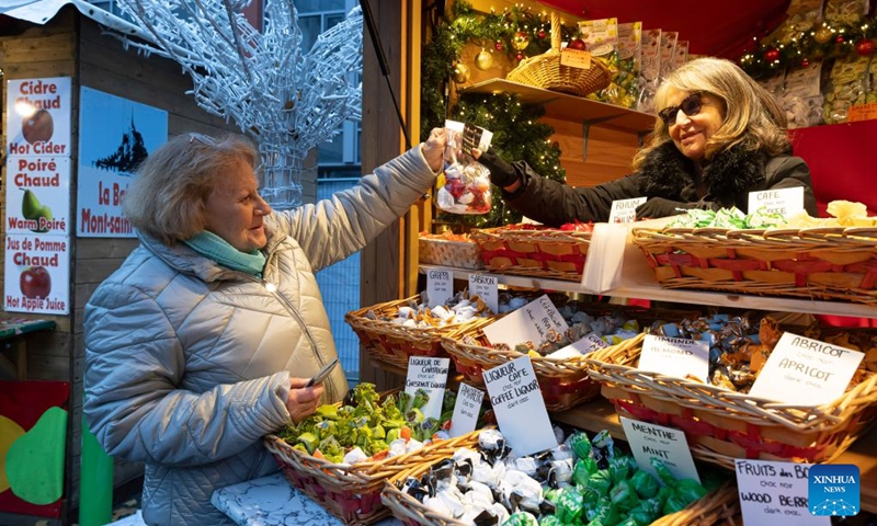 A customer buys candies at the Christmas market in Lille, north France, Nov. 30, 2024. Photo: Xinhua