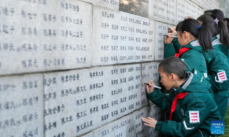 Students use black pens to renew the names on the wailing wall outside the Memorial Hall of the Victims in Nanjing Massacre by Japanese Invaders in Nanjing, east China's Jiangsu Province, Dec. 1, 2024. Photo: Xinhua