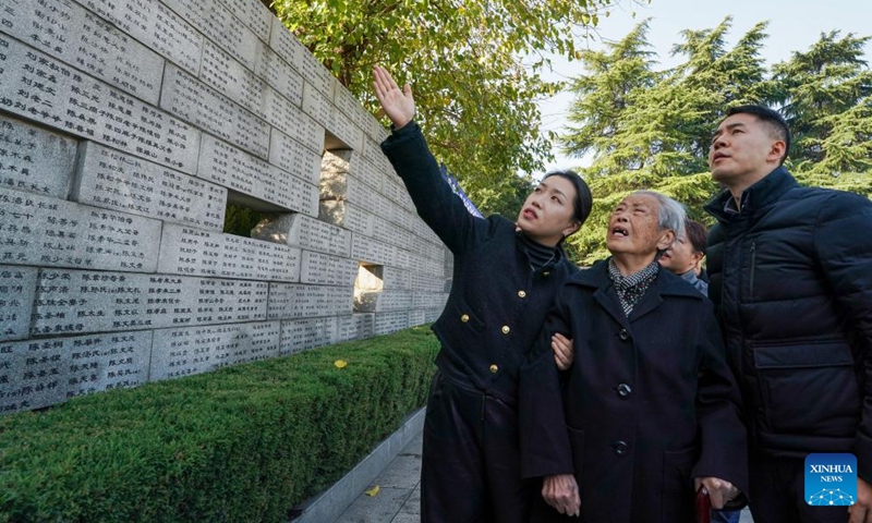 Nanjing Massacre survivors Ai Yiying (2nd R) searches for the names of her relatives, the victims of the Nanjing Massacre, in front of the wailing wall outside the Memorial Hall of the Victims in Nanjing Massacre by Japanese Invaders, in Nanjing, east China's Jiangsu Province, Dec. 1, 2024. Photo: Xinhua